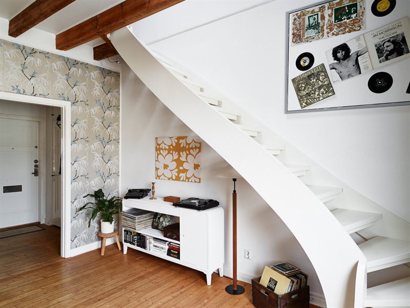 Białe schody w skandynawskim salonie z antresolą