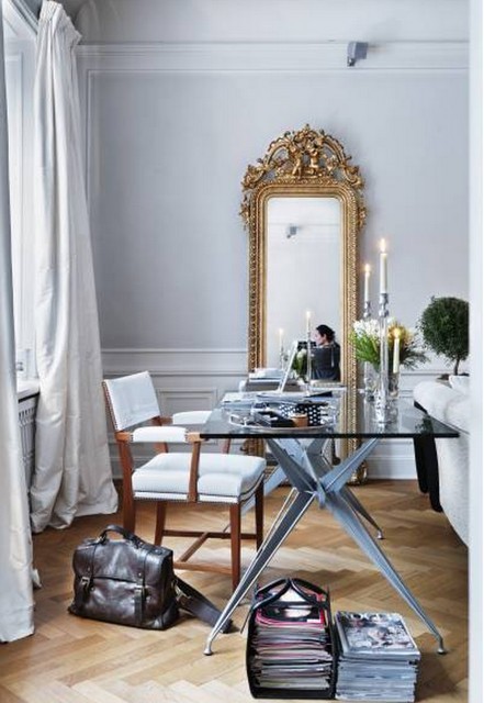 Złocone lustro,szklane nowoczesne  biurko i stylowe krzesło w klasycznym wnętrzu