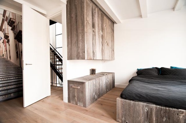 Surowa aranżacja sypialni z prostą zabudową z szarego drewna