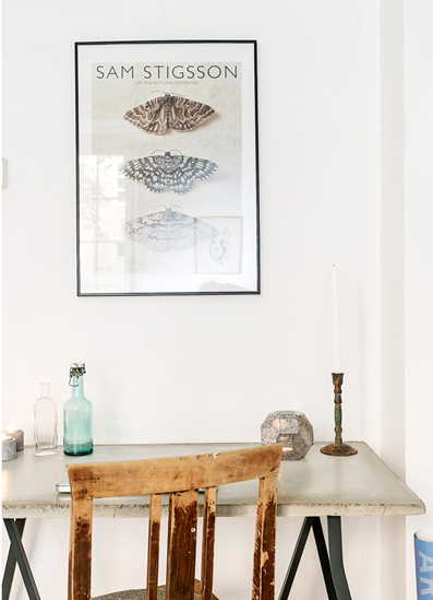 Industrialne biurko na czarnych kozłach i z bielonym blatem vintage,skandynawska grafika na ścianie w domowym biurze