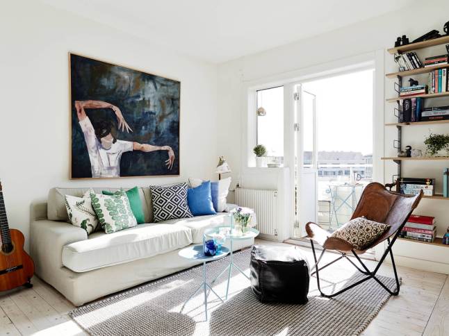Biały salon w stylu skandynawskim z niebieskimi i turkusowymi dodatkami