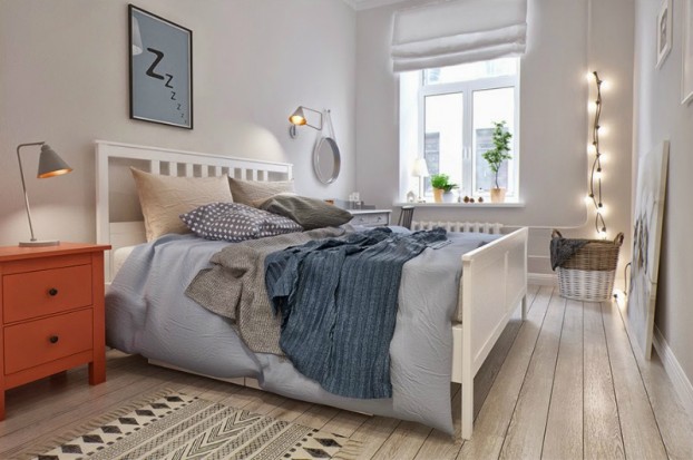Białe łóżko,skandynawski dywanik z marokańskim wzorem,ruda szafka nocna,szara i niebieska narzuta na łóżku i girlanda z żarówkami w aranżacji sypialni w skandynawskim stylu