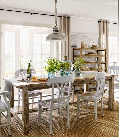Beżowe zasłony,drewbniany stół rustykalny,metalowa patynowana lampoa wisząca i białe krzesła wiejskie w jadalni