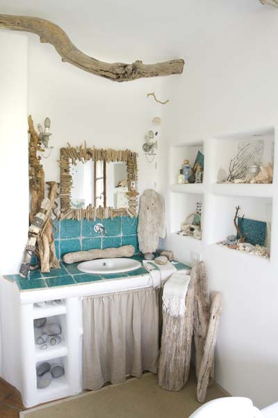 Murowane wnęki i półki, drewniane detale z konarów i turkusowe płytki w łazience