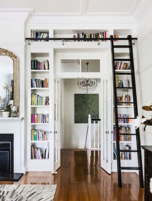 Regały na książki wokół drzwi w małym mieszkaniu