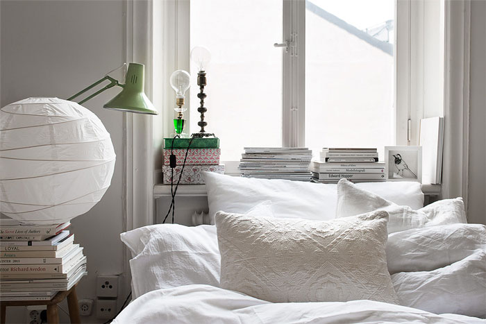 Dekoracja sypialni z białymi poduszkami, narzutą,abażurem z papieru ryżowego i mietowej lampki