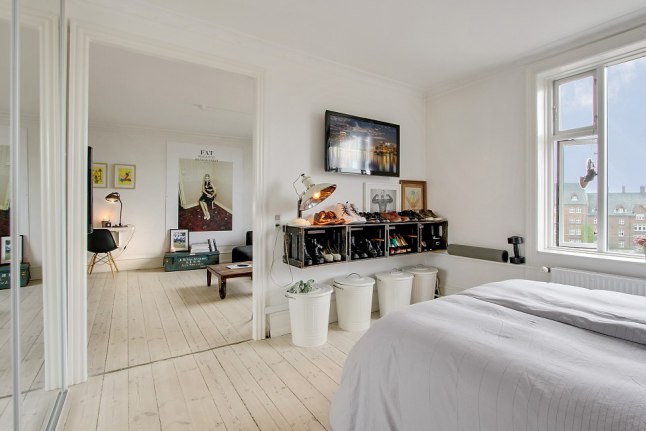 Wiszące półki z drewnianych skrzynek,białe metalowe pojemniki kosze w aranzacji sypialni z podłogą z desek w naturalnym kolorze drewna