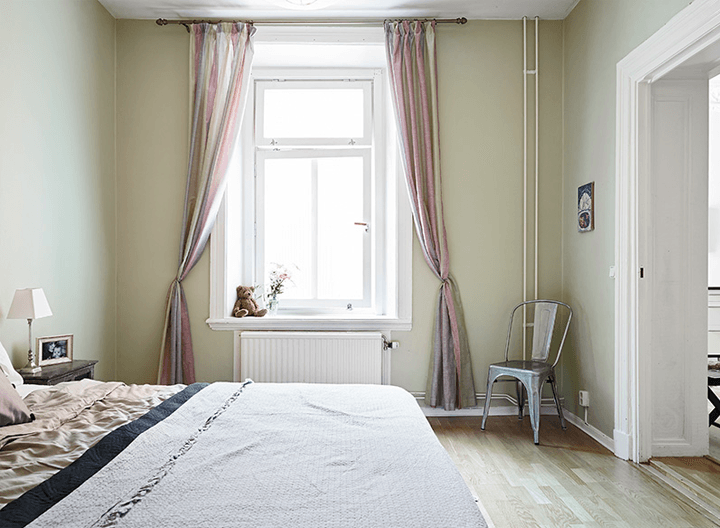 Pastelowa aranżacja sypialni z różowo-szarymi zasłonami na oknie