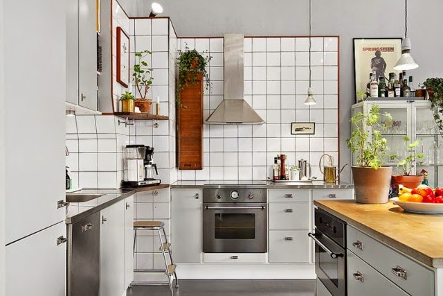 Białe płytki na ścianie w kuchni,stalowy okap,drewniana szafka vintage i szare szafki kuchenne