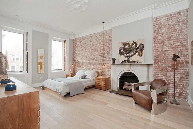 Desingerski fotel ze skóry i metalu w aranżacji sypialni ze ścianami z czerwonej cegły