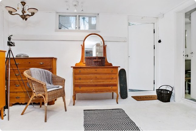 Drewniane miodowe komody i toaletki,bambusowy fotelik,biała podłoga i biało-czarny dywanik
