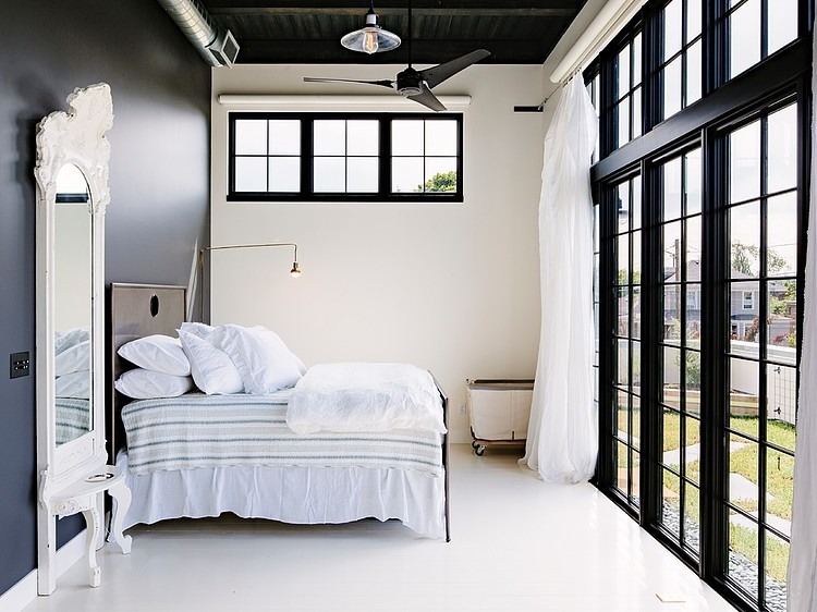 Sypialnia z czarną ścianą i oknami