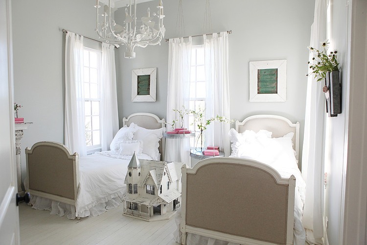 Biały kuty żyrandol i franuskie łóżka w pokoju dziewczęcym