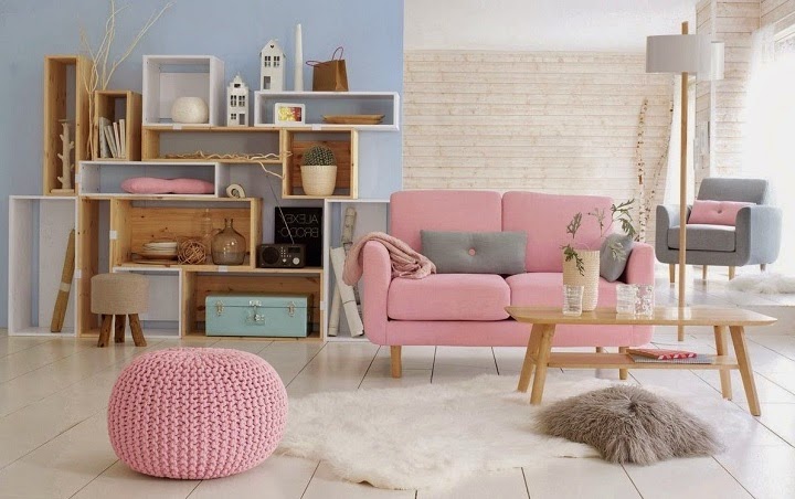 Jasno-niebieskie ściany,różowa sofa,różowy  dziergany puf  w salonie skandynawskim