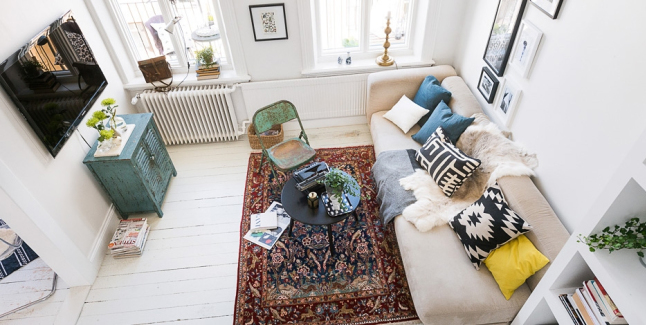 Biały salon skandynawski z turkusową komodą,dywanem vintage,turkusowym metalowym krzesłem i beżową sofą z poduszkami