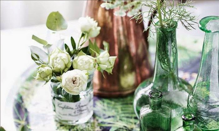 Biało-zielona aranzacja wiosennego stołu,szklane słoje dekoracyjne,zielone butle i wazony szklane,botaniczne plakaty na ściany,drewniany stół w wiosennej dekoracji,wiosenna aranżacja jadalni,obrusy i serwety w z botanicznymi wzorami,botaniczne