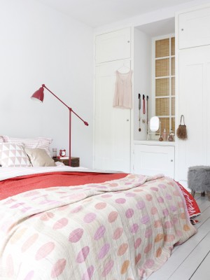 Biała sypialnia z różowa lampą i narzutą na łóżko