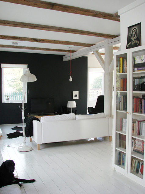 Czarna ściana  i biała sofa w salonie