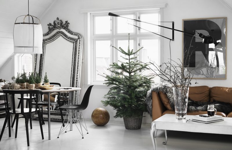 Stylowe duże lustro stojące,biały stolik na srebrnych ludwikowskich nóżkach,zielona surowa choinka w ocynkowanym wiadrze w salonie w eklektycznym  stylu