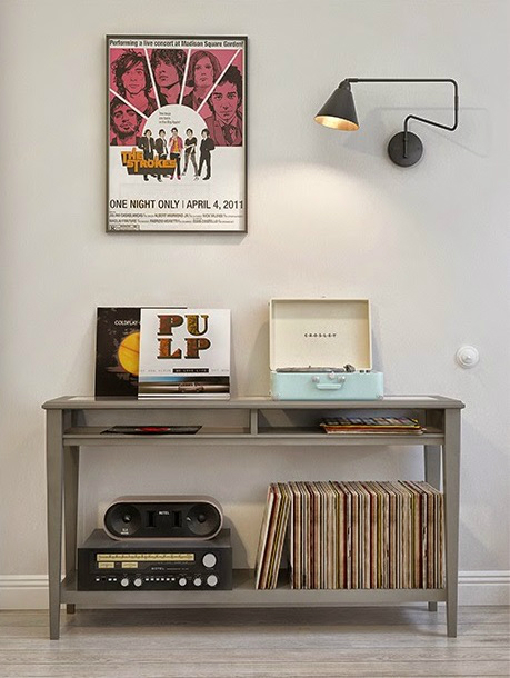 Szara konsolka,muzyczny plakat na ścienie,czarny kinkiet i bielone deski na podłodze