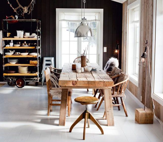 Prosty drewniany stół ,drewniane giete krzesła,biała podłoga,czarna ściana i industrialne metalowe lampy w aranżacji jadalni
