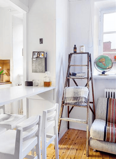 Biała lada z krzesłami na granicy kuchni z salonem