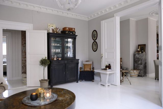 Eklektyczne wnętrze w skandynawskim mieszkaniu w bieli, szarościach  i czerni