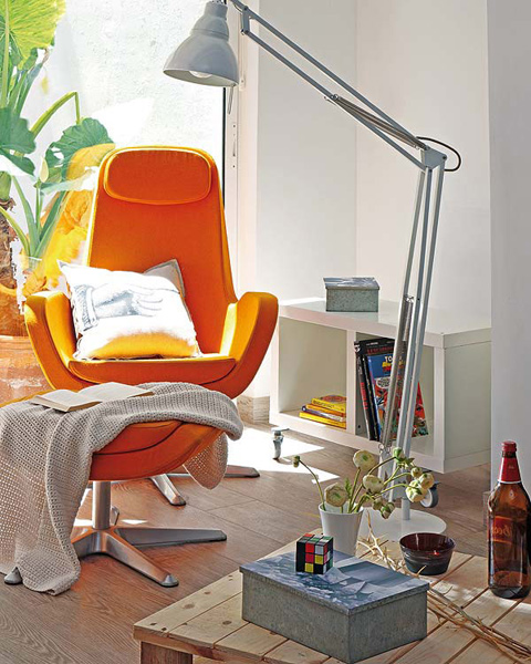 Małe mieszkanie w stylu małego loftu z pomarańczowym fotelem