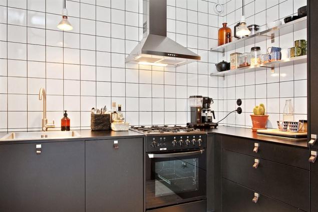 Czarne szafki stojące, białe półki wiszące i biała glazura w kuchni