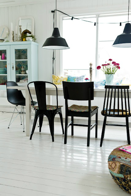 Biały stół z drewna  z czarnymi krzesłami z metalu, drewna i tworzywa