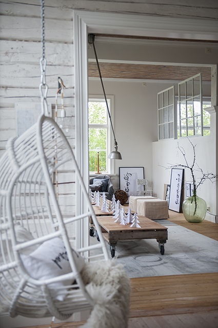 Wiszący fotel z wikliny w skandynawskim domu