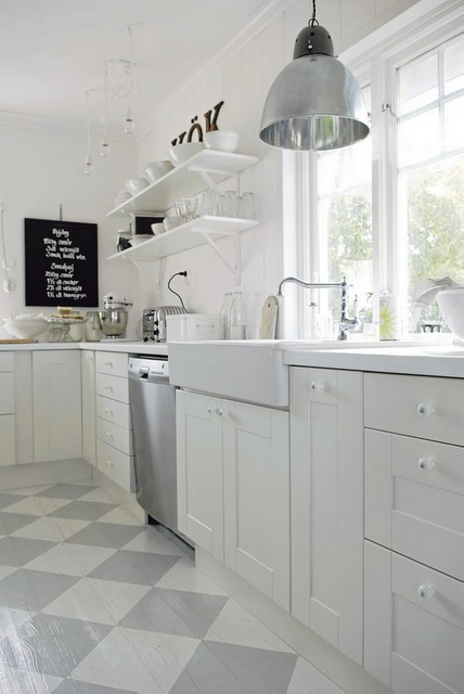 Szaro-biała terakota ułożona w karo w białej kuchni skandynawskiej