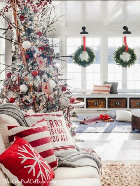Czerwone dodatki świąteczne i wieńce w oknach salonu