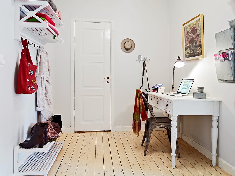 Tradycyjne białe biurko skandynawskie,białe półki wiszące na buty i ubrania,drewniana podłoga z wąskich desek,metalowa szara pólka na gazety,metalowe szare krzesło  industrialne