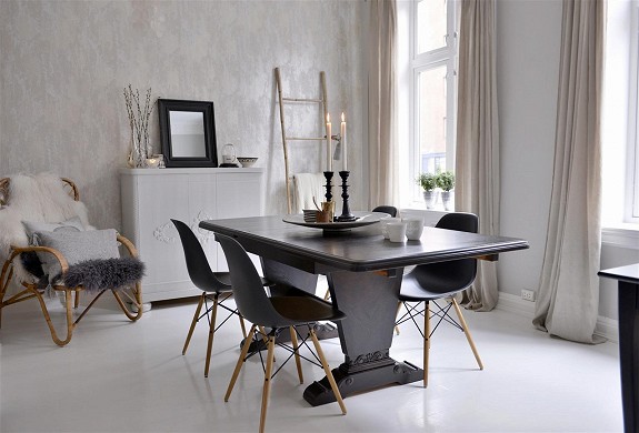 Szara jadalnia w zmiksowanym stylu z drabiną,nowoczesnymi krzesłami i drewnianym czarnym stołem