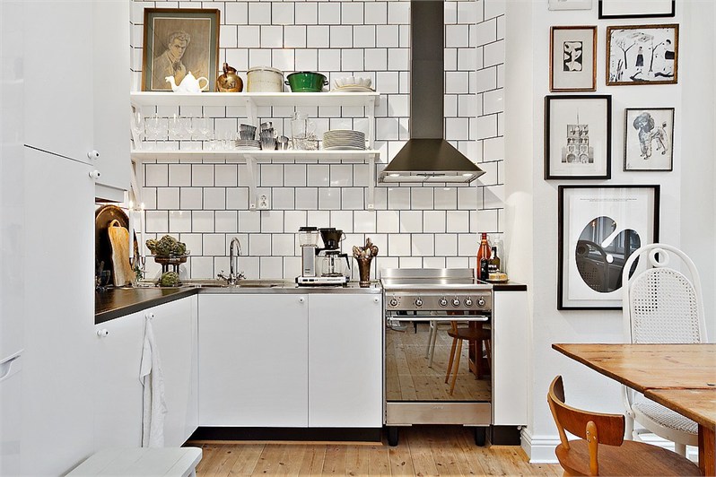 Grafiki,plakaty i obrazy retro w aranżacji białej kuchni w stylu skandynawskim